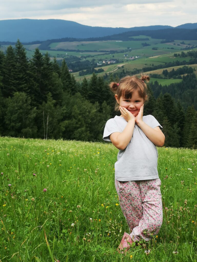 Uśmiechnięta dziewczyna na placu zabaw w samochodziku