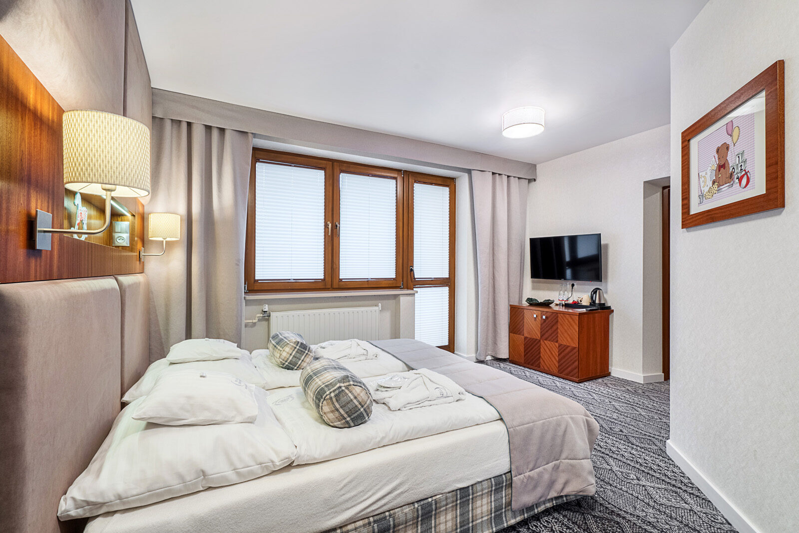 Sypialnia w apartamencie Mezzanine z wielkim oknem i łożem oraz TV