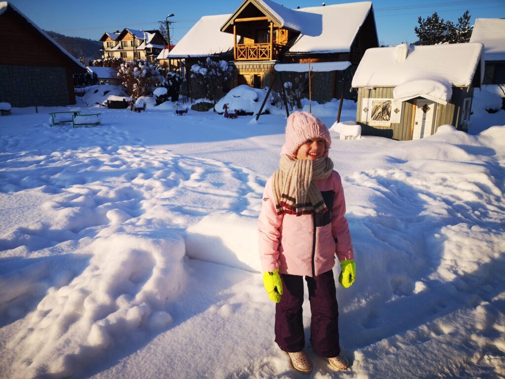 Uśmiechnięta dziewczyna na placu zabaw w samochodziku