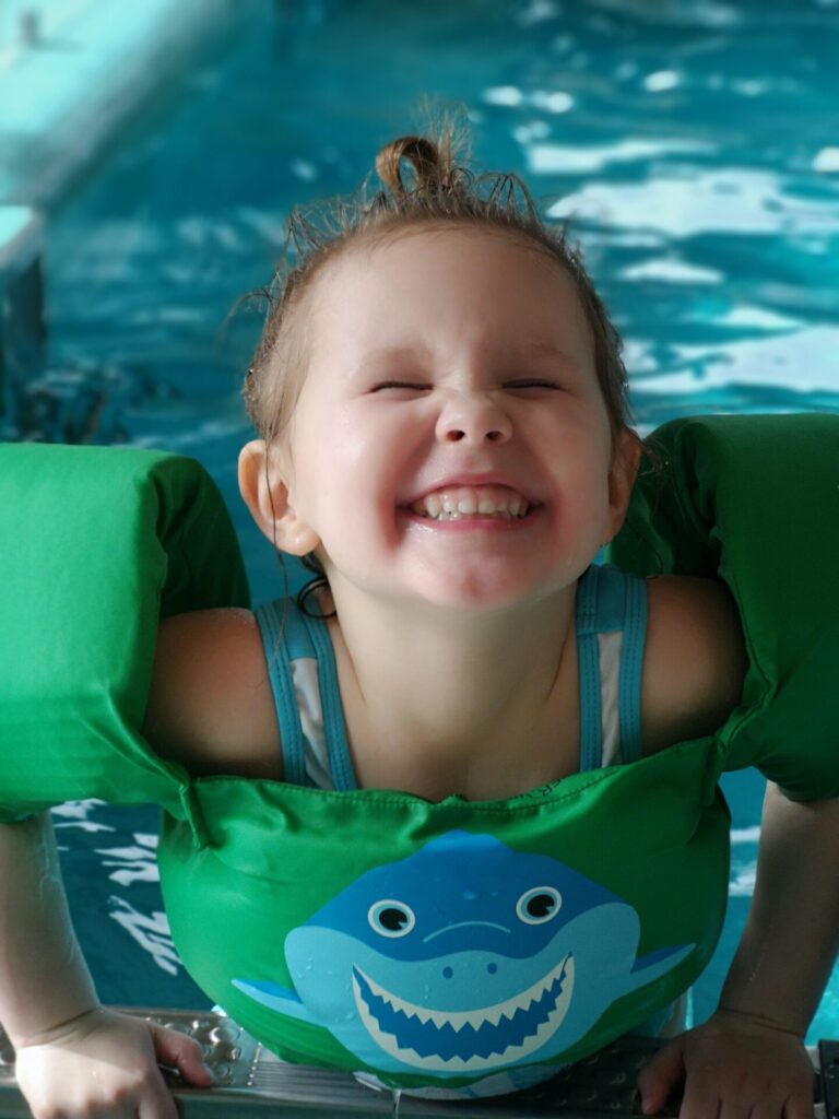 Uśmiechnięta dziewczyna na placu zabaw w samochodziku